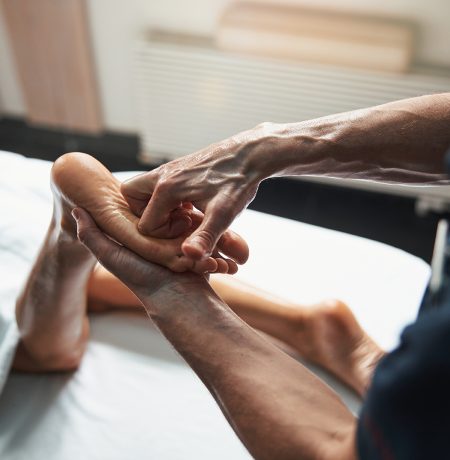 Close up top view portrait of elegant charming female legs in manual therapist hands receiving spa massage in wellness center