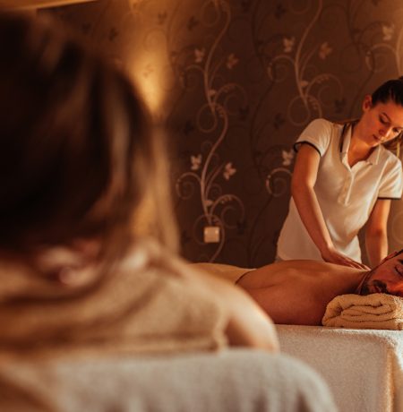 Female masseur massaging male at a spa
